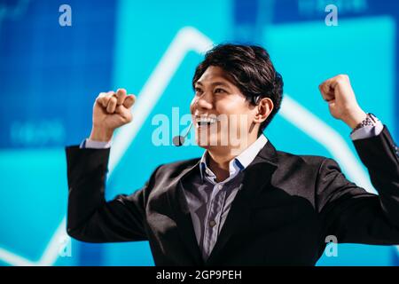 Asian Businessman Stands on Stage for Business Presentation Stock Photo