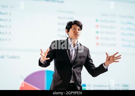 Asian Businessman Stands on Stage for Business Presentation Stock Photo