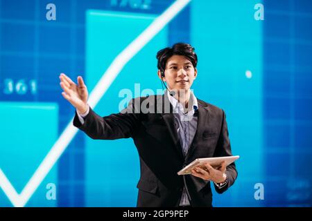 Asian Businessman Stands on Stage for Business Presentation Stock Photo
