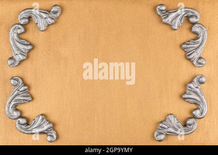 Luxury frame made of silver stucco plaster lying on golden surface, with space for your text Stock Photo