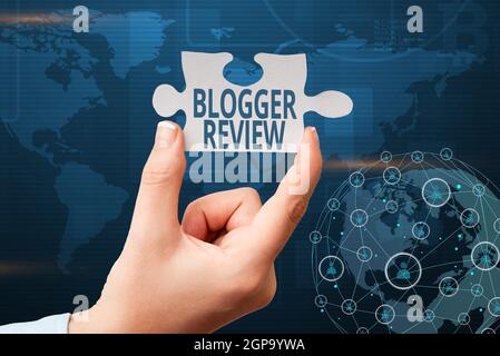 Hand writing sign Blogger Review. Business approach making a critical reconsideration and summary of a blog Hand Holding Jigsaw Puzzle Piece Unlocking Stock Photo