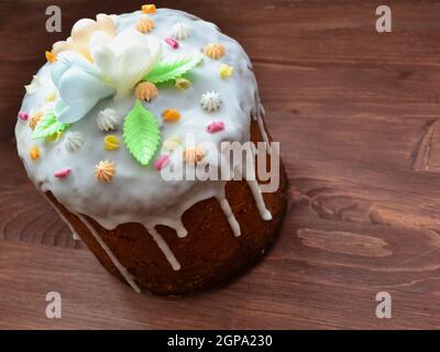 Easter cake with icing and colorful sweet topping on brown wooden table Stock Photo