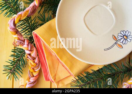 Empty rustic light plate over pastel table. Flat lay, with spruce branch Stock Photo