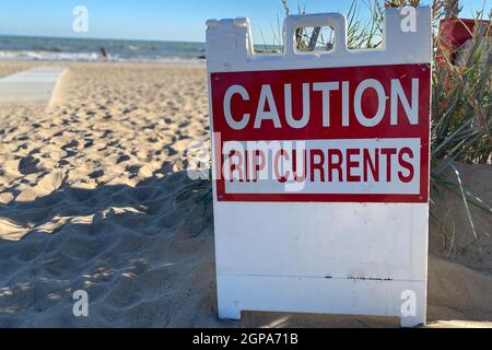 Caution Rip Currents sign at the entrance to Gillson Beach on Lake Michigan's Illinois shore on a windy day. Stock Photo