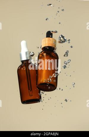 Bottles of essential oil in water on color background Stock Photo