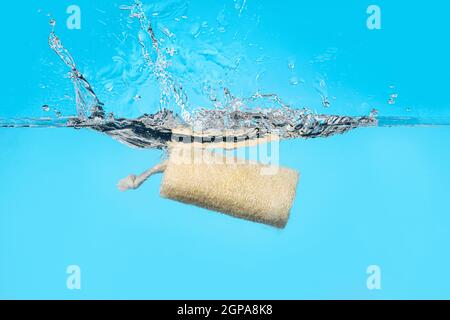 Loofah in water on color background Stock Photo