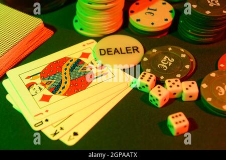 Poker chips, playing cards and dices on dark background Stock Photo