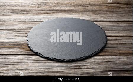 Stone plate placed on a wooden background, concept for composition Stock Photo