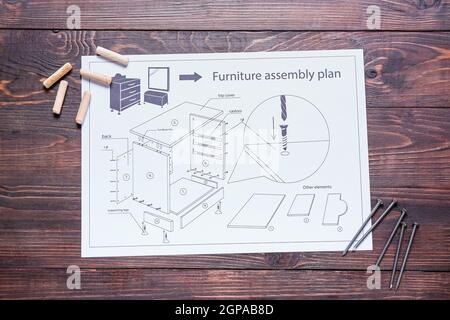 Furniture assembling plan, dowels and nails on wooden background Stock Photo