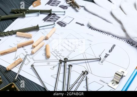 Furniture assembling plan, nails, dowels and screws on table Stock Photo