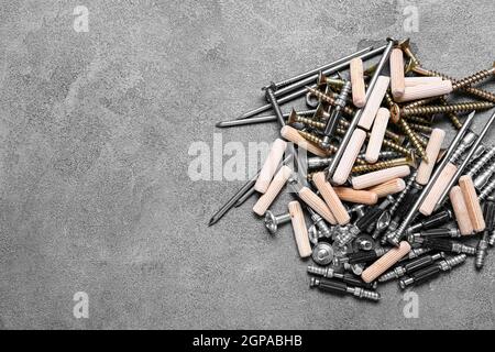 Pile of different nuts, bolts, screws, nails and dowels on grey background Stock Photo