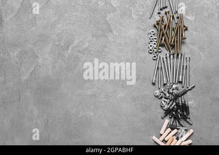 Different nuts, bolts, screws, nails and dowels on grey background Stock Photo
