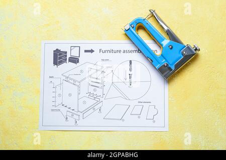 Furniture assembling plan and stapler on color background Stock Photo