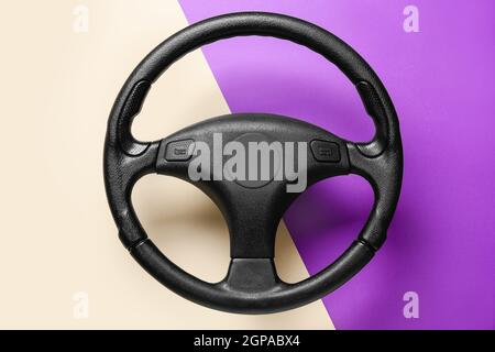 Steering wheel on beige and purple background Stock Photo