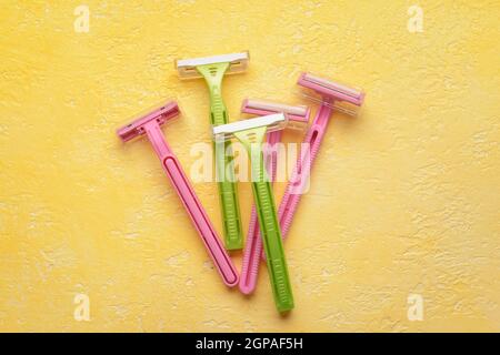 Many different razors for depilation on yellow background Stock Photo