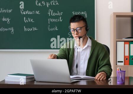 Asian teacher conducting English lesson online Stock Photo