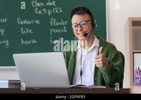 Asian teacher conducting English lesson online Stock Photo