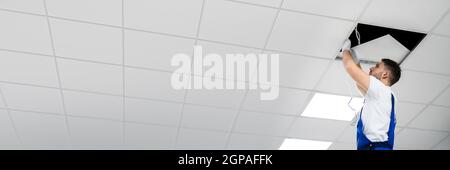 Electrician On Ladder Installing Office Lights On Ceiling Stock Photo ...