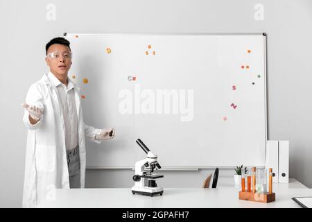 Asian teacher conducting chemistry lesson Stock Photo
