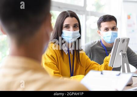 Young woman in medical masks working in office Stock Photo