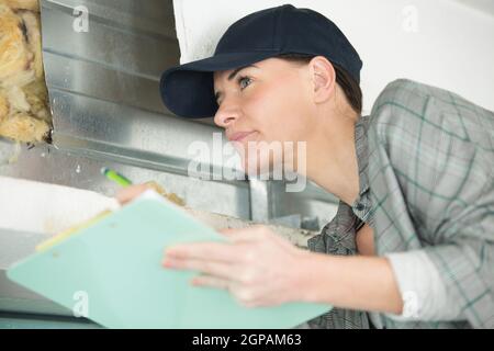 female contractor on site holding clipboard Stock Photo