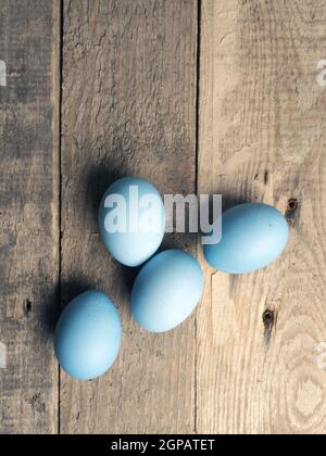 Naturally colored organic eggs on a rustic table with space for text, Easter background Stock Photo