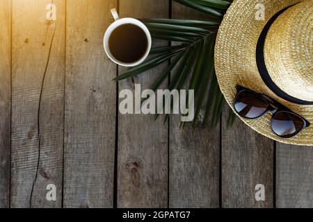 Travel, vacation concept. Hat, palm leaf, coffee cup, eyeglasses on wooden background. Relax. High quality photo Stock Photo