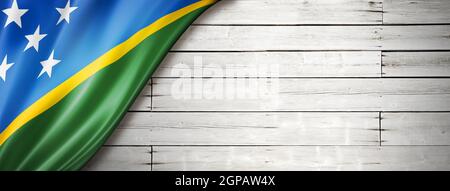 Solomon Islands flag on old white wall. Horizontal panoramic banner. Stock Photo