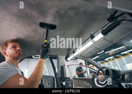 Portrait of worker use car interior steam cleaner. Vapor sterilization  Stock Photo - Alamy