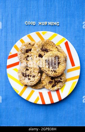 Oatmeal cookies with chocolate on blue napkin inscription good morning. Stock Photo