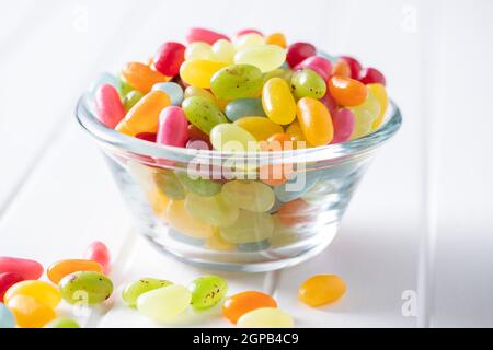 Sweet colorful jelly beans in bowl on white table. Stock Photo