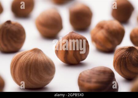Hazelnuts scattered on a white background, whole, selective focus. The concept of healthy eating. Stock Photo