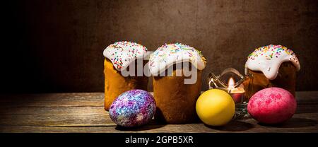 Easter cakes and Easter colored eggs on a dark background. Religious holiday of bright Easter. Stock Photo