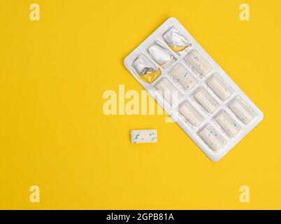 rectangular pieces of gum in a blister pack on a yellow background, copy space Stock Photo