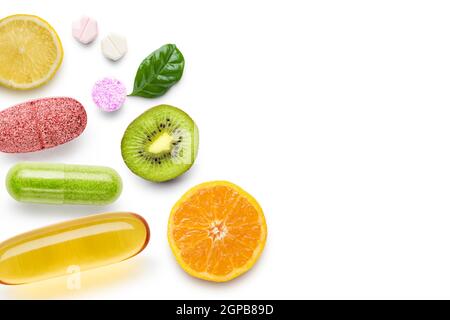 various vitamin supplement pills with citrus fruits on white background Stock Photo