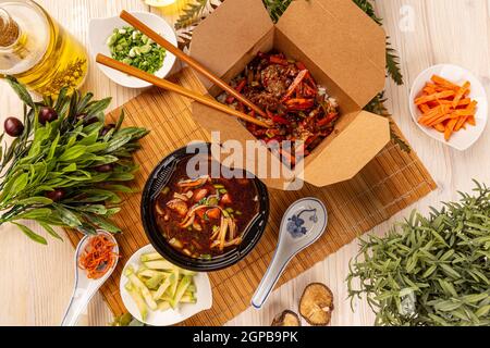 Flat lay of Chinese food in boxes, soup and main course Stock Photo