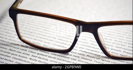 Closeup of eyeglasses on paper sheet with lorem ipsum text. Stock Photo
