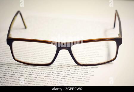 Closeup of eyeglasses on paper sheet with lorem ipsum text. Stock Photo