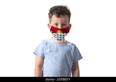 Respirator with flag of Kiribati White boy puts on medical face mask isolated on white background. Stock Photo