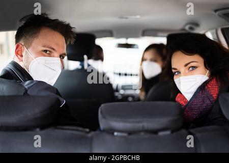 Carpool Ride Share. Friends Enjoy Taxi In Face Mask Stock Photo