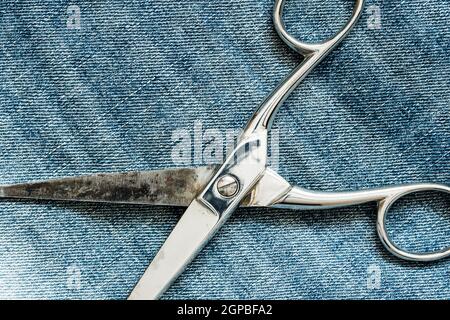Metal scissors laying on the jeans background Stock Photo - Alamy