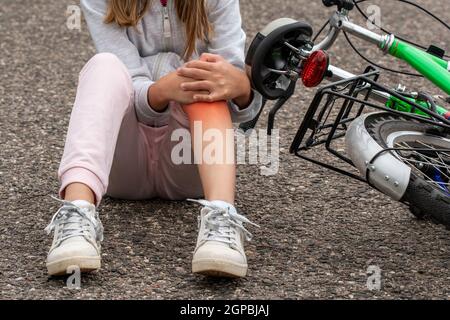 Girl in pain after a bicycle accident. Kids safety concept Stock Photo