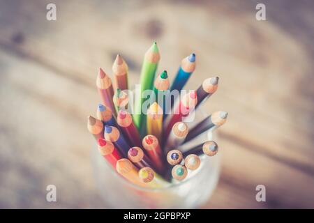 Colored pencils in a can on rustic wooden table Stock Photo