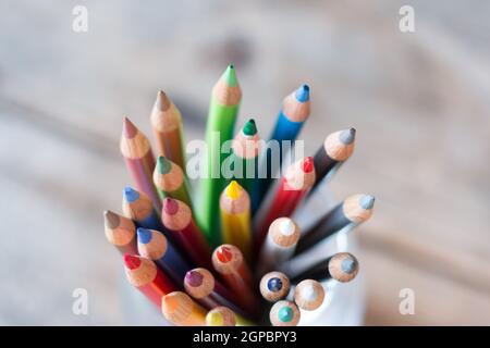 Colored pencils in a can on rustic wooden table Stock Photo