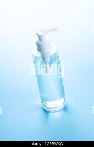 Coronavirus prevention hand sanitizer gel in bottle. Hand disinfectant gel on blue table. Stock Photo