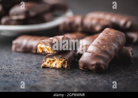 Chocolate bars with nuts filling on black table. Stock Photo