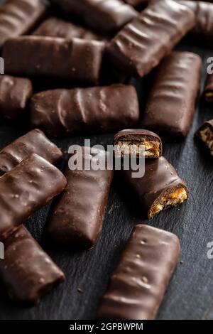 Chocolate bars with nuts filling on black table. Stock Photo
