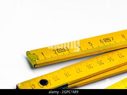 Detail of a folding wooden meter. Measuring tool for construction and renovation works. Graduated scale in centimeters. Stock Photo