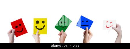 Collection of hands holding a paper with smiley face isolated on white background. Stock Photo