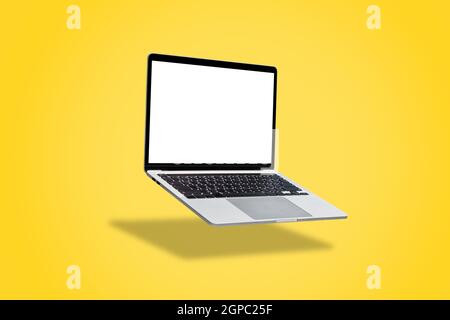 Laptop computer with blank screen, floating on a yellow background. Stock Photo
